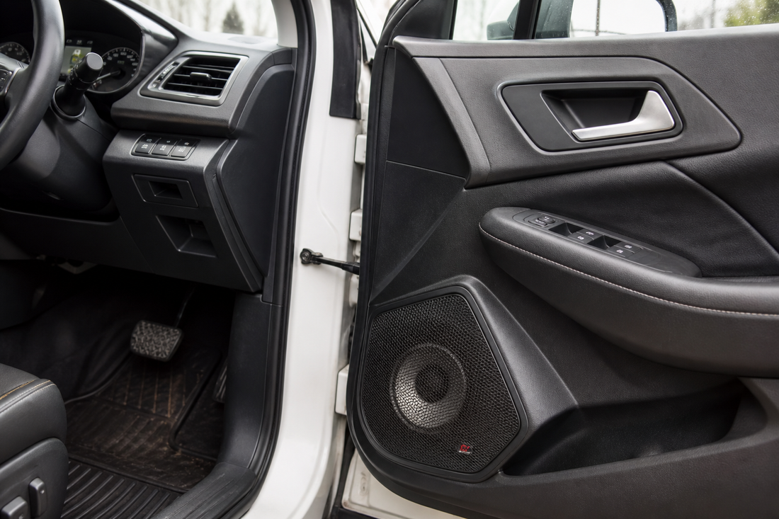 Upgraded car door speakers installed in a car interior without a subwoofer box