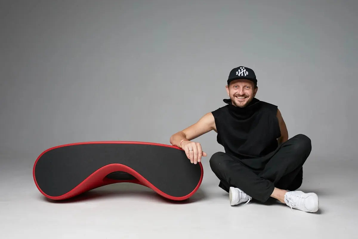 a man sitting on the ground next to a skateboard