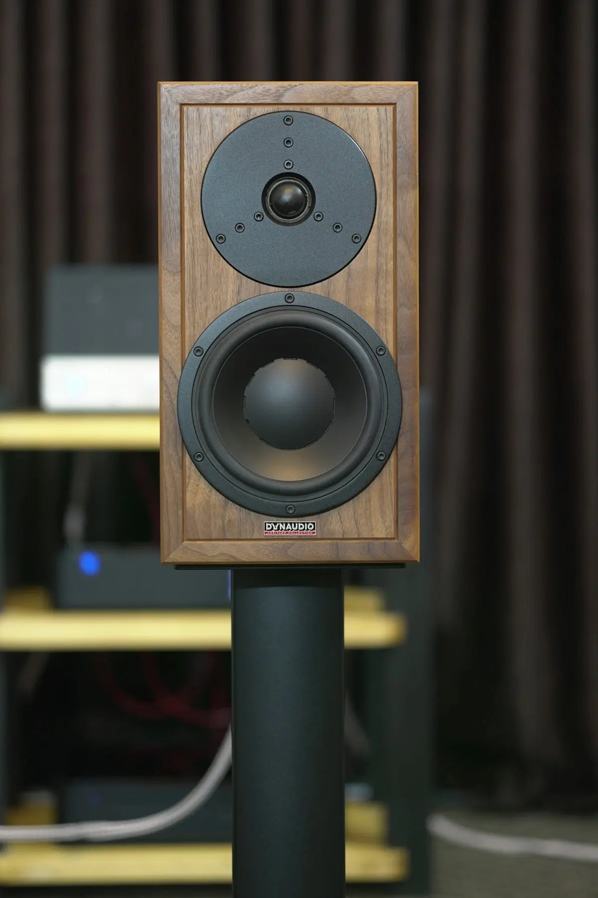 A wooden speaker sits on a stand.