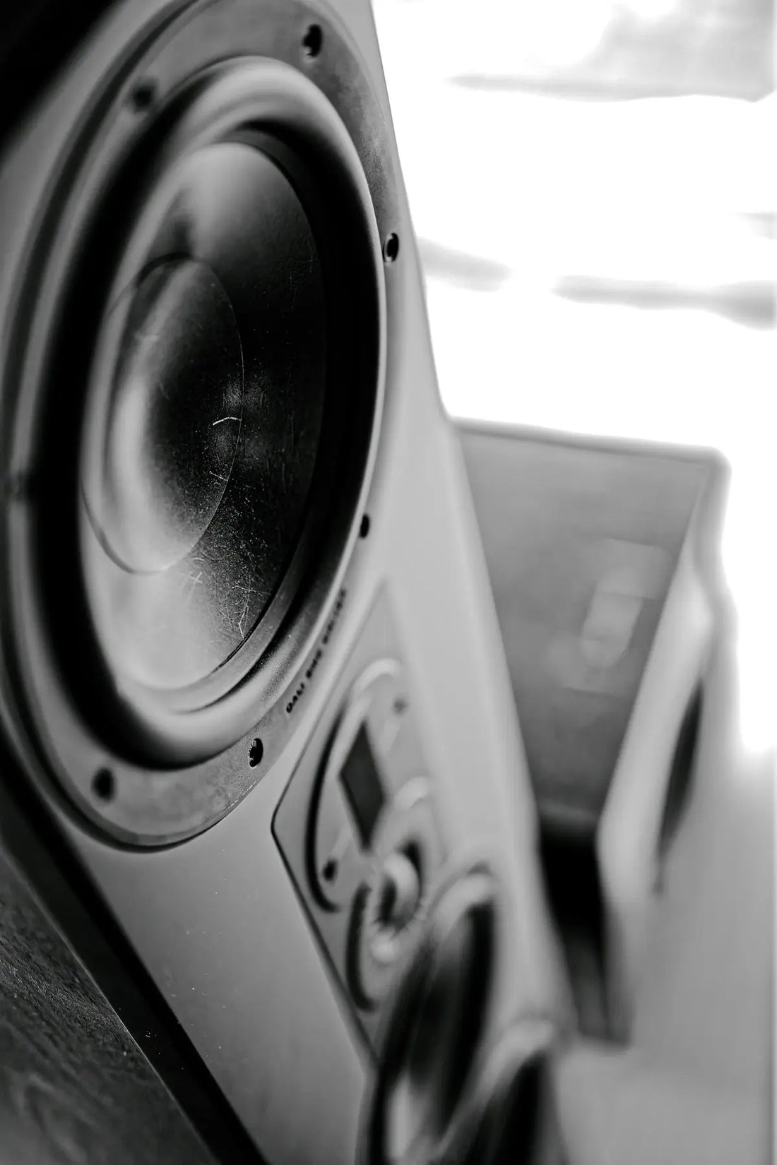 Close-up of a black speaker with a textured cone.