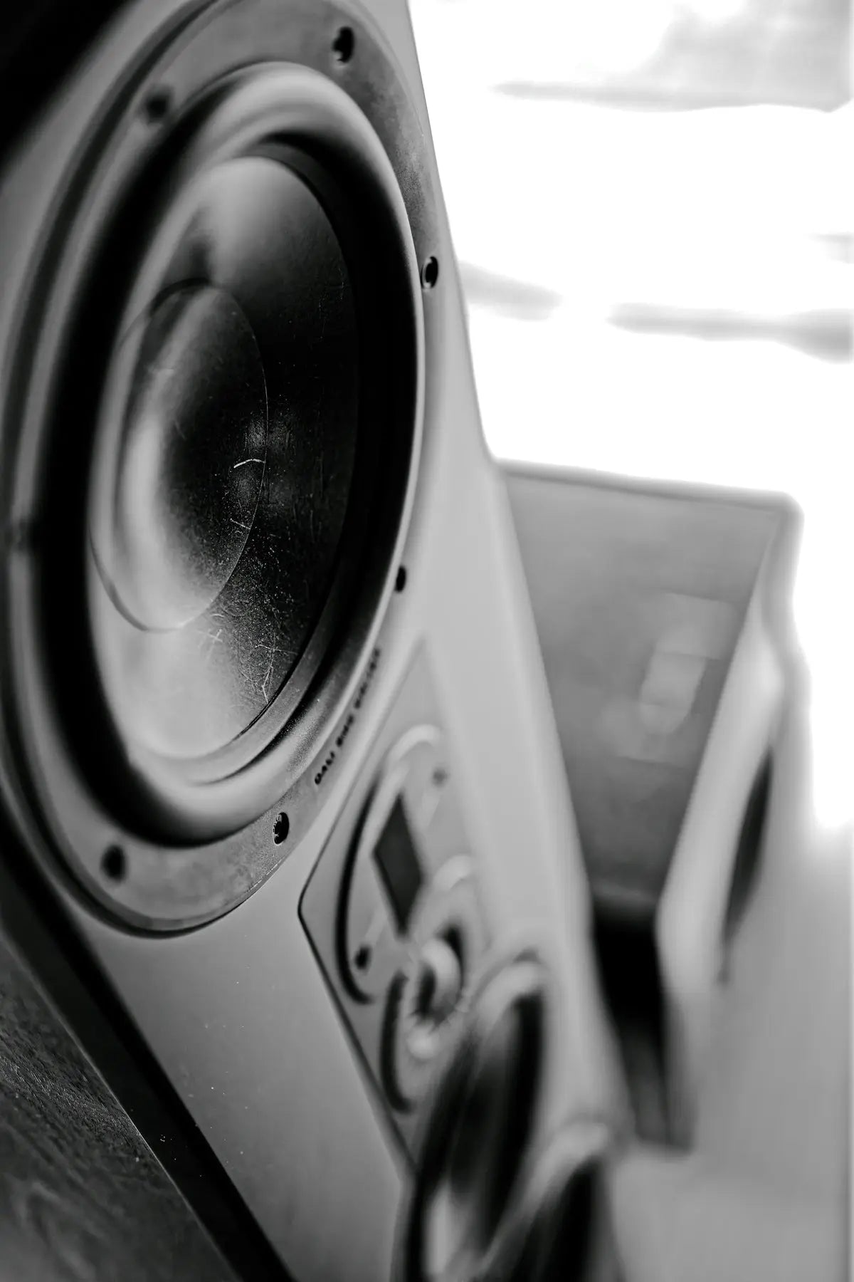 Close-up of a black speaker with a textured cone.